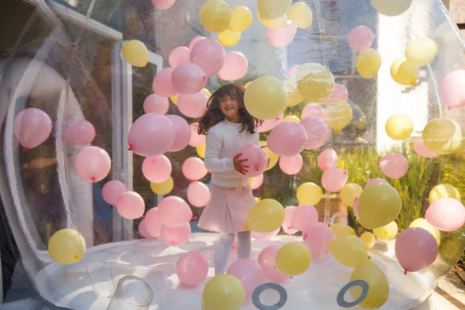 Criança brincando entre as bexigas da Bubble House Bolimbolá