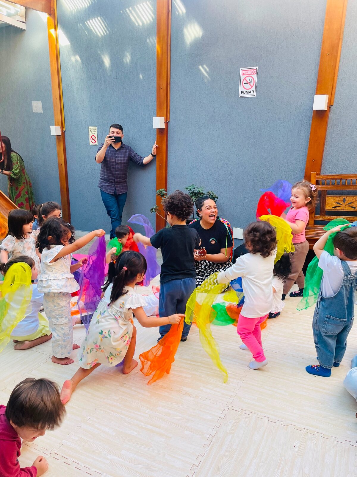 Crianças dançando com tecidos coloridos durante a Roda Musical Bolimbolá